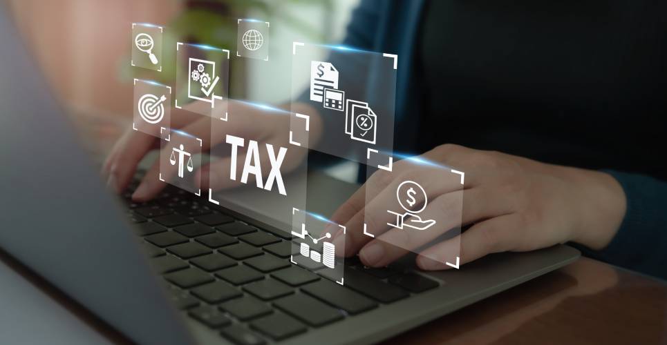 A person typing on a laptop computer with several digital app icons superimposed on the image, including the word "tax."